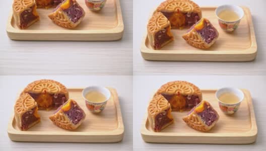 中国月饼紫地瓜和蛋黄味的茶在木盘上高清在线视频素材下载