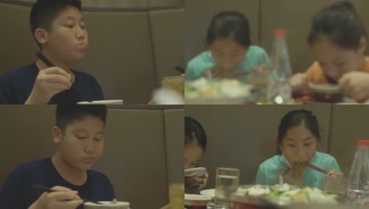 快乐4亚洲儿童与家人一起在餐厅吃素喜烧、涮涮锅或火锅，生活方式理念。高清在线视频素材下载