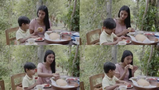 慈祥的母亲和她的儿子在一个农村家庭吃早餐，两人看起来都很高兴高清在线视频素材下载