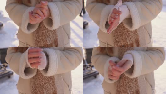 特写镜头冻僵的无法辨认的女人搓手试图在寒冷的冬天站在户外取暖。高清在线视频素材下载