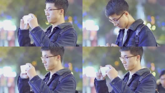 亚洲男子学生晚上在校园里拿着手机高清在线视频素材下载