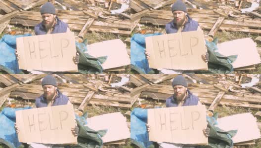 一名无家可归的男子在废墟附近用一个指示牌帮助，帮助在疫情期间贫穷和饥饿的人们高清在线视频素材下载