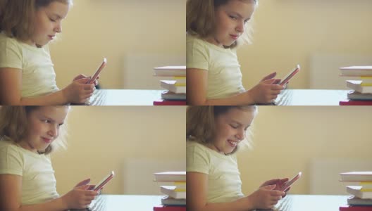 一个女孩正在玩手机游戏。网络成瘾。他巧妙地微笑。使用手机高清在线视频素材下载