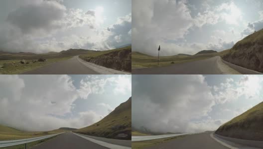 在有山和多云的山顶的弯道上驾驶汽车的快速时间推移的POV高清在线视频素材下载