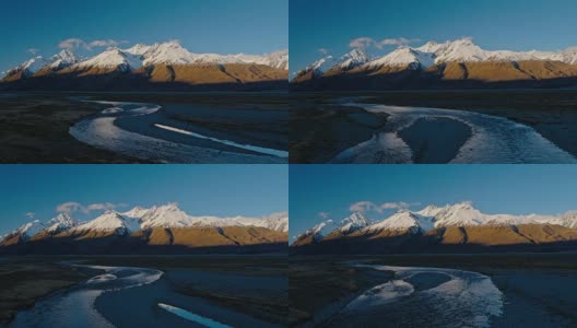 鸟瞰图飞过雪融化的河流，朝向新西兰雪山的山峰高清在线视频素材下载