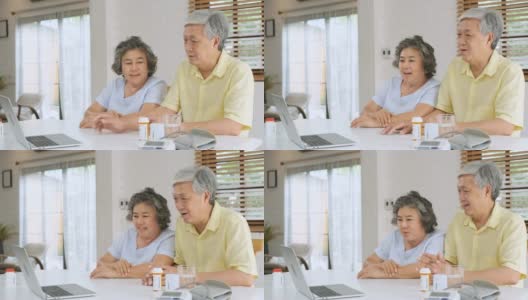 亚洲夫妇老年人使用笔记本电脑视频会议与医生有关的疾病和处方药丸在家里的客厅。健康的生活方式。居家养老概念高清在线视频素材下载
