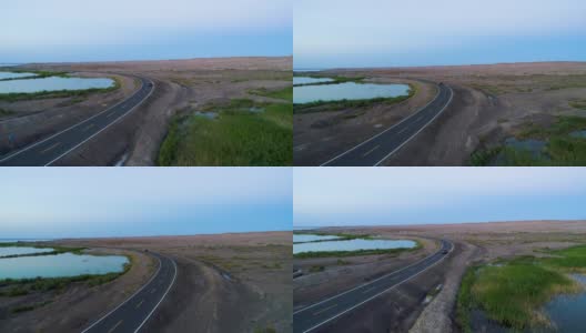 日落时分，汽车在沙漠中间的空旷道路上行驶的鸟瞰图高清在线视频素材下载