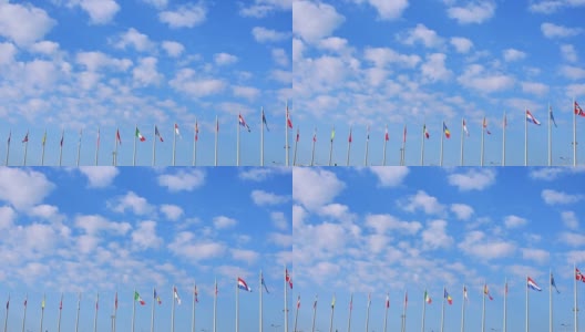 在晴朗的日子里，不同国家的国旗在风中飘扬，映衬着蓝天和白云。高清在线视频素材下载