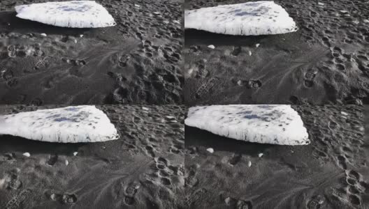 白色的冰在黑色的沙滩上高清在线视频素材下载