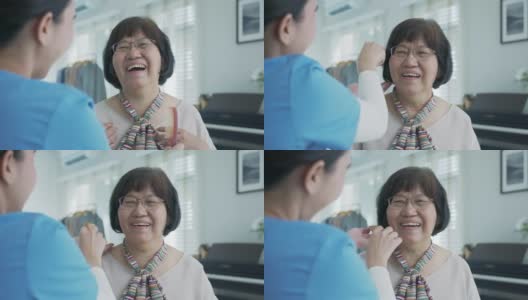 有魅力的年轻老年亚洲女性公民开心的脸在早上与护士在家例行生活方式，头发刷梳头，亚洲护理在家照顾志愿者，协助生活的服务理念。高清在线视频素材下载