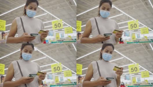 女人戴着防护面具在网上刷信用卡，网上购物高清在线视频素材下载
