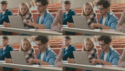 在教室里男女同学分享和使用笔记本电脑，在课堂上聊天。正在学习的年轻人。大学的生活。高清在线视频素材下载