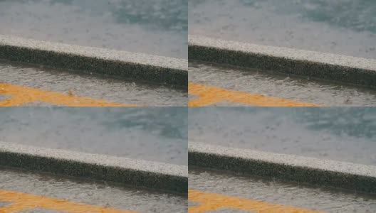 几滴大雨落在沥青上。热带降雨高清在线视频素材下载