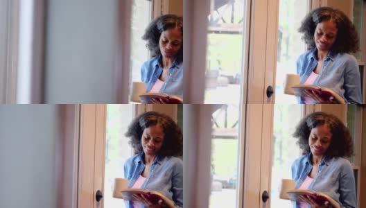 成熟的非裔美国妇女微笑着读她的圣经高清在线视频素材下载