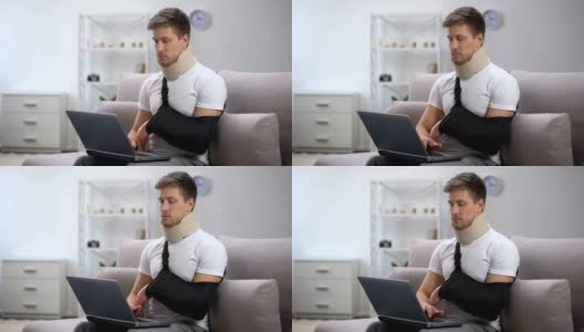 男性在泡沫颈圈和手臂吊带打字一只手在笔记本电脑上，自由职业者高清在线视频素材下载