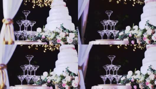 金字塔的空香槟酒杯在婚礼设置倒香槟与模糊的背景。高清在线视频素材下载