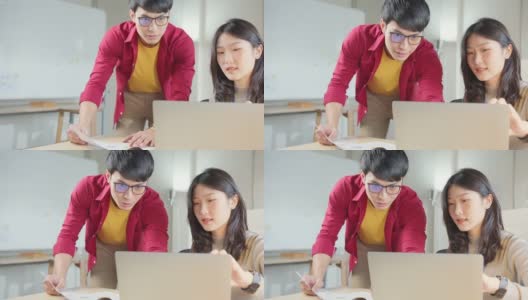 亚洲男性创意高级设计师同事在办公室向年轻的ux ui初级设计师咨询如何作为一个团队解决问题高清在线视频素材下载