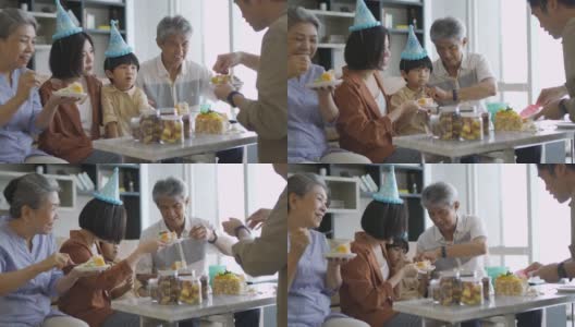 亚裔华人父亲在儿子的生日庆典上给儿子送蛋糕高清在线视频素材下载