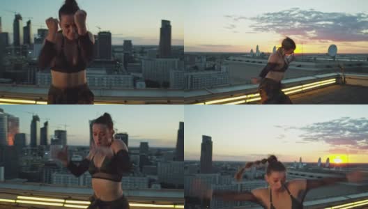 现代，女舞者表演在照明的屋顶。日落时分的城市全景高清在线视频素材下载