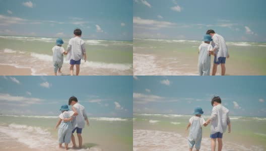 慢镜头快乐的两个亚洲男孩孩子在夏天的一天在海滩玩水。家庭中的兄弟姐妹关系高清在线视频素材下载