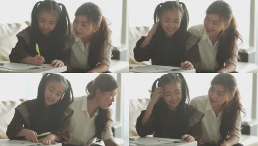 亚洲华人年轻的家庭母亲和女儿周末在客厅公寓里做家庭作业，享受亲子时光高清在线视频素材下载