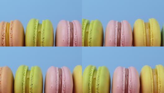 五彩马卡龙，法式马卡龙，甜美可口的甜点。孤立在蓝色背景上。高清在线视频素材下载