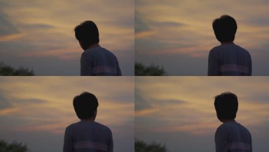 一个印度人在日落时看橙色云彩的剪影。人类仰望天空，寻找希望。孤独的概念。孤独寂寞的人仰望天空。高清在线视频素材下载