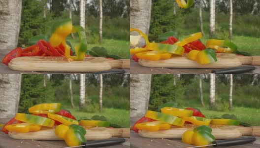 新鲜的黄胡椒片以慢动作落在木板上高清在线视频素材下载