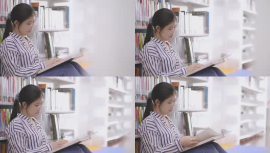 亚洲女孩坐在图书馆看书高清在线视频素材下载