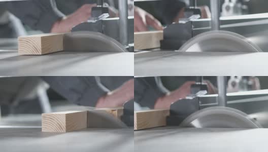一名专业工人用金属圆锯片切下一块木板。高清在线视频素材下载