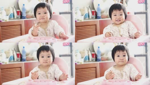4K:高椅上可爱可爱的女婴。婴儿吃手指食物和玩耍的肖像高清在线视频素材下载