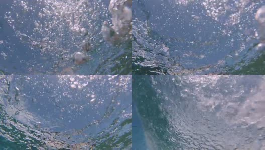 水下:在一个阳光明媚的日子里，巨大的管状波浪掠过相机。高清在线视频素材下载