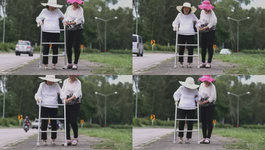 女儿照顾在强烈阳光下行走的老妇人。高清在线视频素材下载