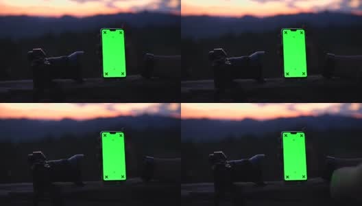 特写的摄影师扫智能手机与绿色屏幕与自然戏剧性的天空作为背景，色度键高清在线视频素材下载