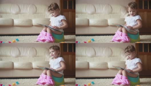 聪明的小女孩坐在马桶上看书。高清在线视频素材下载