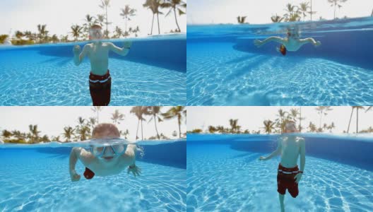 小男孩在热带度假胜地的游泳池里游泳高清在线视频素材下载