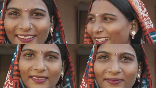 一个美丽的印度女人的脸的极端特写，微笑着，笑着，快乐着，快乐着，看着镜头，穿着传统服饰，头戴宾蒂，漂亮的珠宝，在家里，自由爱静态拍摄锁定高清在线视频素材下载