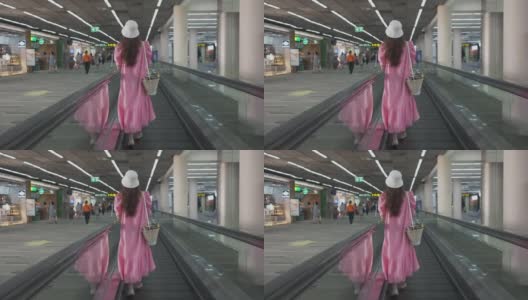 亚洲女游客在机场出发大厅使用移动走道前往登机门。现代化机场，高速移动人行道。高清在线视频素材下载