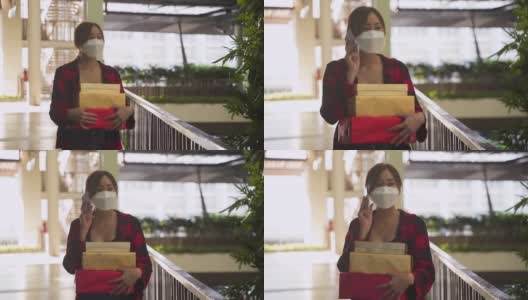 亚洲女人用手机戴着口罩拿着礼物盒高清在线视频素材下载