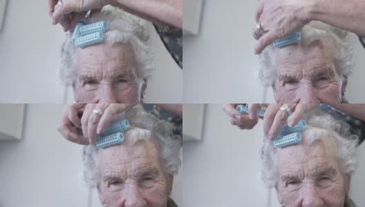 一个专业护理发型师的特写镜头在一个年长的白人妇女的洗发集或在家里烫发高清在线视频素材下载