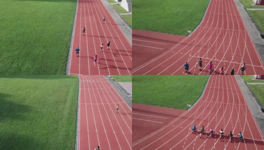 从无人机的角度看，亚洲华人运动员在田径场上排起了短跑队，并在早上跑向终点线高清在线视频素材下载
