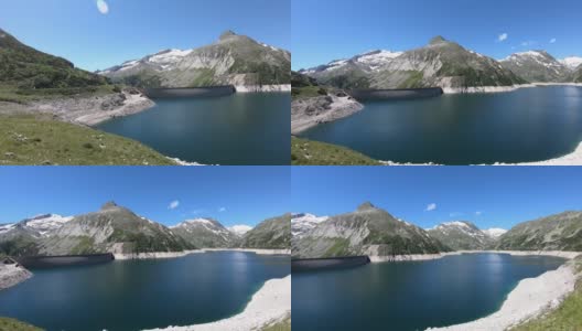全景式的人工湖在科隆布雷因大坝在卡林西亚，奥地利。大坝被高山积雪覆盖的山峰包围着。陡峭的斜坡。这个湖是深蓝色的。自然能源高清在线视频素材下载