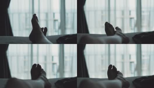 一个放松的女人躺在床上，交叉腿在毛毯上，在酒店度假胜地看风景高清在线视频素材下载