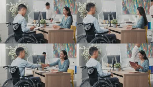 男人们坐在轮椅上坐在办公室的桌子前，对面是一个穿着裙子的漂亮女人，一个同事带来一份他们签署的合作合同，他们互相感谢对方的面试高清在线视频素材下载
