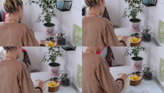 年轻漂亮的女人正在做新鲜的柠檬水高清在线视频素材下载