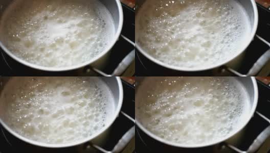 用开水煮的米在不锈钢锅里猛烈地沸腾高清在线视频素材下载