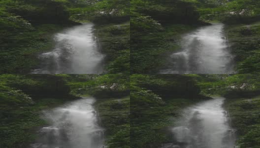 垂直和缓慢的动作瀑布在雨林。高清在线视频素材下载