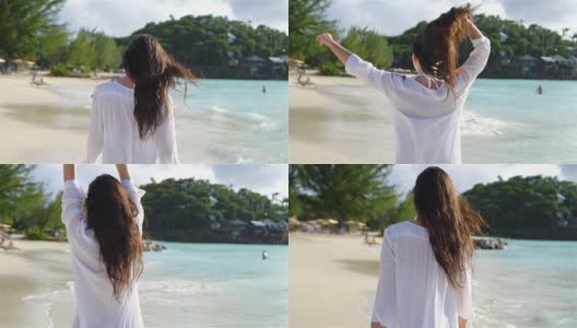 年轻美丽的女人在白色的热带沙滩上高清在线视频素材下载