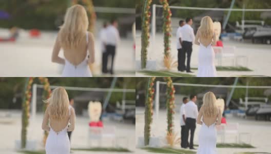 初见新婚夫妇。新娘在一个浪漫的热带小岛上，在蔚蓝的泻湖海洋附近的白色沙滩上举行婚礼高清在线视频素材下载