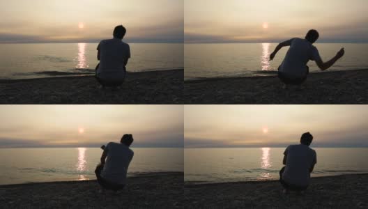 日落时分，一名男子在伊利湖上跳石头高清在线视频素材下载